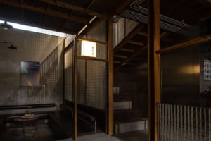 Modern stairwell with wooden stairs, metal railing, and a bench, giving off a sleek and modern vibe
