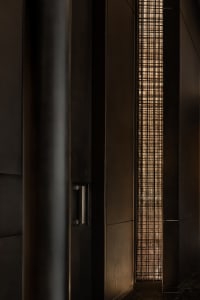Wooden hallway with a metal grate covering a window, two doors on either side, and a cozy atmosphere