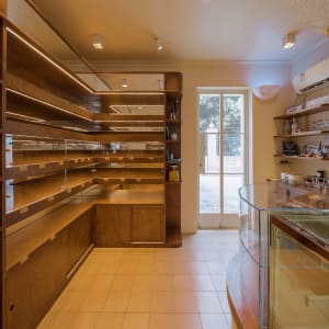 A well-organized retail space with display window, bookshelves, bottles, and handbags on display