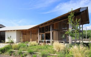 A house with a wooden exterior, a large deck, and several windows, creating a warm and inviting atmosphere
