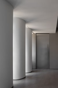 Empty industrial hallway with concrete walls and white pillars, creating a sense of simplicity and modernity