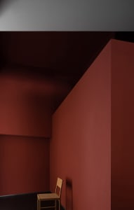 A room with a red concrete wall, surrounded by a depth-filled environment