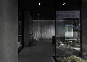 Empty modern room with a black floor, two glass doors, and a minimalist atmosphere