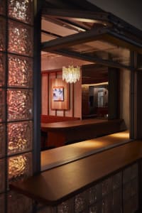 A cozy restaurant dining area with a wooden table, chairs, and a warm atmosphere