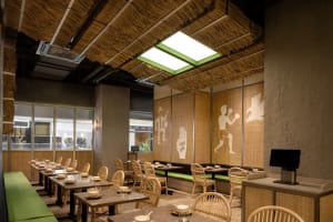 Warm and inviting restaurant interior with wooden furniture, woven wallpaper, and a cozy atmosphere