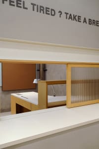 An organized office space with a desk, two chairs, a keyboard, mouse, and a book, suitable for work or study