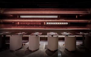 Warm and inviting restaurant interior with wooden walls and tables, set with wine glasses and chairs