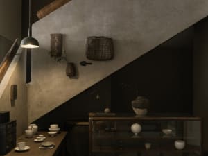 Cozy interior stairwell with a wooden table at the bottom, featuring vases and cups, and a warm inviting atmosphere