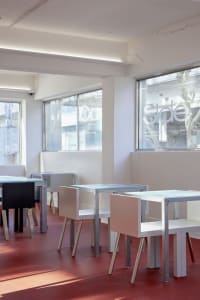Modern restaurant interior with white walls, dining tables, and chairs, creating a clean and contemporary atmosphere