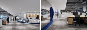 Spacious office with modern design, large windows, chairs, dining table, and mounted TVs, creating a comfortable environment