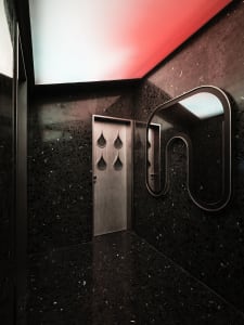 Black marble bathroom with a red accent wall, modern design, and sleek contemporary feel