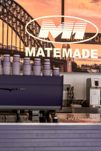 A cozy coffee shop interior with a purple espresso machine, cups, and inviting atmosphere