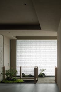 A bright and inviting indoor space with potted plants, vases, and a large window allowing sunlight to enter