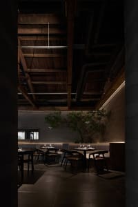 Empty restaurant dining area with wooden tables and chairs, wine glasses, and a calm atmosphere
