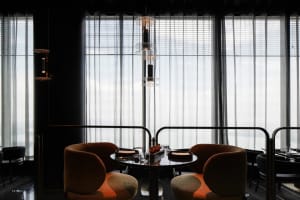 A formal dining area with two round tables and four chairs, featuring place settings and decorative accents, set in a well-lit space