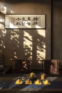 Dimly lit room with two chairs and a table, featuring Asian-inspired design elements and a cozy atmosphere