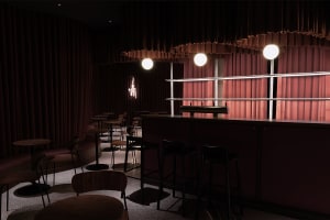Cozy bar area with red walls, chairs, and dining tables, inviting atmosphere for socializing and enjoying drinks
