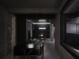 Empty modern restaurant with black interior, dining tables, and chairs, creating a sophisticated atmosphere