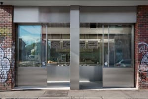 Industrial kitchen with stainless steel appliances and surfaces, dim lighting, and a focus on practicality and durability