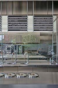 Industrial kitchen with stainless steel counters, multiple sinks, and commercial appliances, designed for efficient food preparation and storage