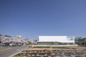 A modern building with a large white concrete facade, clean lines, and a minimalist aesthetic