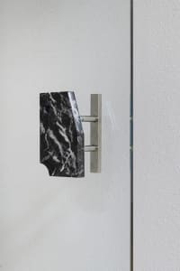 Bathroom with marble countertop, black marble design, and towel racks on either side of the wall