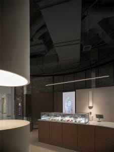 Modern retail space with a large glass display case showcasing jewelry and accessories, highlighted by well-designed lighting