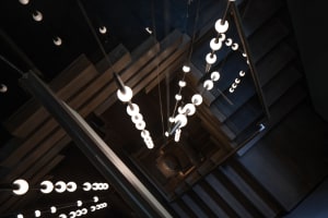 A modern hotel stairwell with wooden steps and lights, creating a well-lit atmosphere