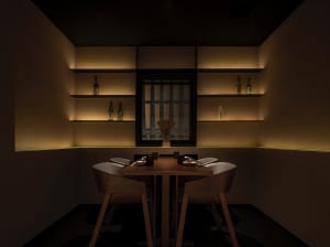 Dimly lit dining area with a wooden table, chairs, and bottles, creating a sophisticated atmosphere