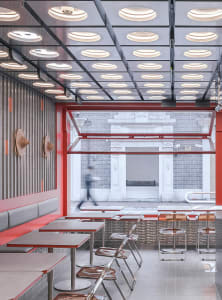 Inviting restaurant interior with red walls, tables, and chairs, creating a comfortable atmosphere for dining