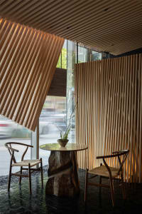 Inviting restaurant interior with wooden walls, tables, and chairs, set against a backdrop of a busy urban street with parked cars
