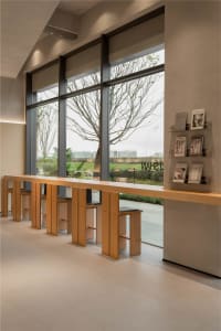 Bright lobby with large windows, benches, and bookshelves in a modern building