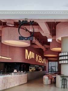 Inviting restaurant interior with pink walls, chairs, and a dining table in a large open area