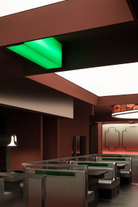 A restaurant dining area with multiple tables and chairs, warm lighting, and a welcoming atmosphere