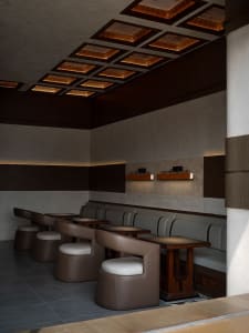 Warm and inviting restaurant interior with brown wooden walls and tables, featuring chairs and a cozy atmosphere