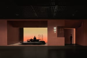 Warm and inviting Asian restaurant interior with a dining table, chairs, and a couch, featuring pink walls and a cozy atmosphere