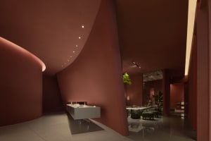 A modern bathroom with a curved red wall featuring two sinks, creating a unique and stylish space with a warm ambiance