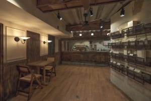 Cozy cafe interior with wooden floors and walls, featuring chairs and dining area with cups and bowls scattered throughout