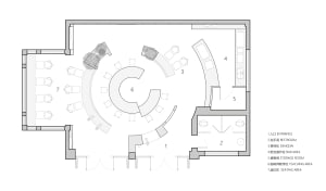 A modern office space with a circular hub surrounded by various rooms, including a dining area and a kitchen, with chairs placed throughout for gatherings or meetings