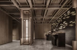 Dimly lit restaurant interior with wooden walls and floors, featuring two sinks and a modern aesthetic