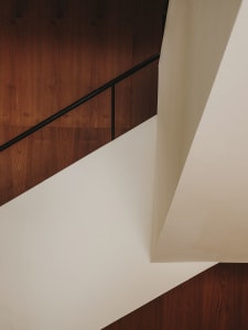 A well-lit staircase with wooden steps, set in a simple and functional space