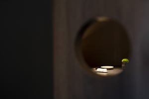 A dimly lit room with a unique wooden door and two white plates on a table