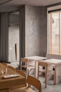 Dining area with wooden tables, chairs, and wine glasses, set in an elegant and inviting atmosphere