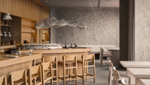 Inviting restaurant interior with wooden stools, chairs, and dining tables, featuring bottles and a warm atmosphere