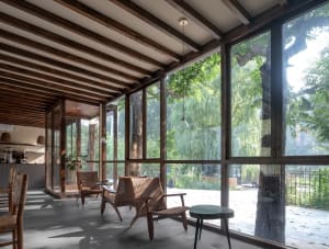 Well-lit living area with wood flooring, large windows, and comfortable seating options