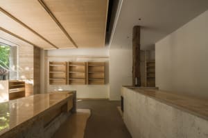 Modern kitchen with wooden cabinets and shelves, well-lit with natural light from windows