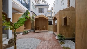 Three small wooden structures in a courtyard area, suggesting a cozy and functional environment