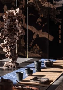 an oriental interior design featuring a wooden table with several bowls and a vase, blending traditional and modern elements