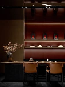Dining area with a wooden table, chairs, and various decorative items, creating a sophisticated ambiance