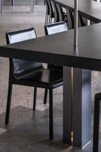 Empty modern dining space with a metal table and leather chairs in a contemporary setting